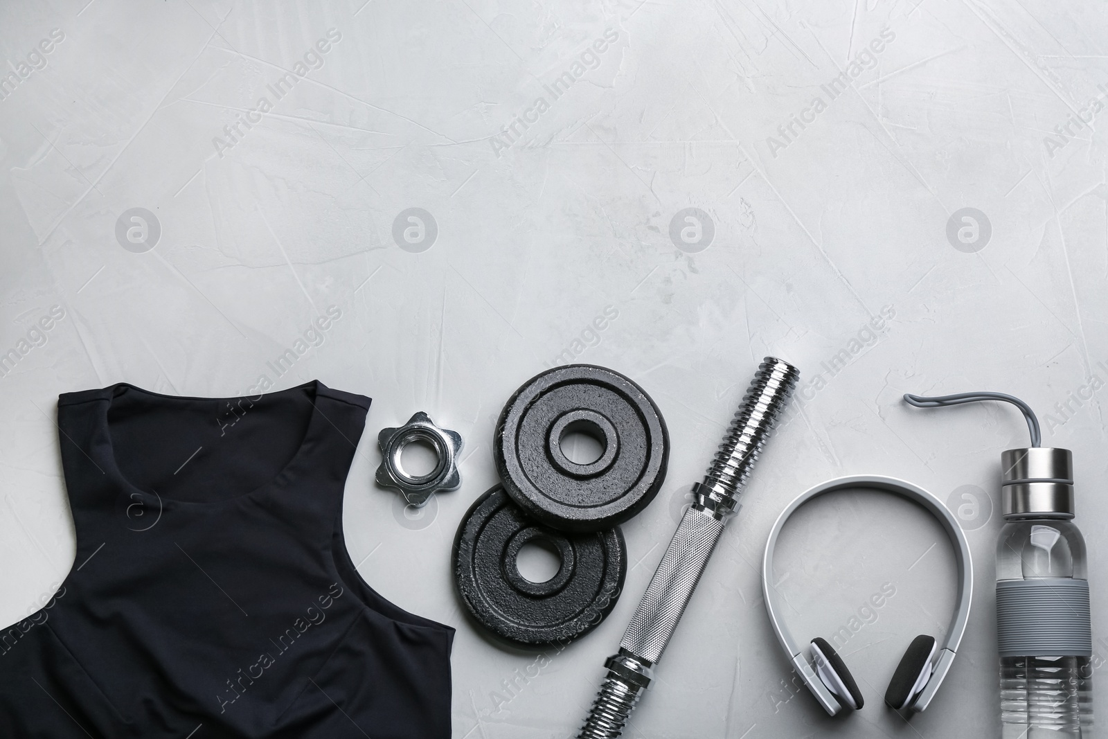 Photo of Flat lay composition with sportswear and equipment on light grey table, space for text. Gym workout