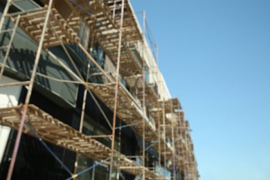 Photo of Blurred view of unfinished building with scaffolding against blue sky