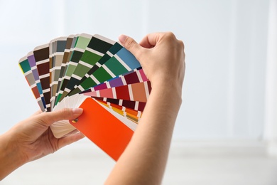 Photo of Female interior designer with color palette samples indoors, closeup