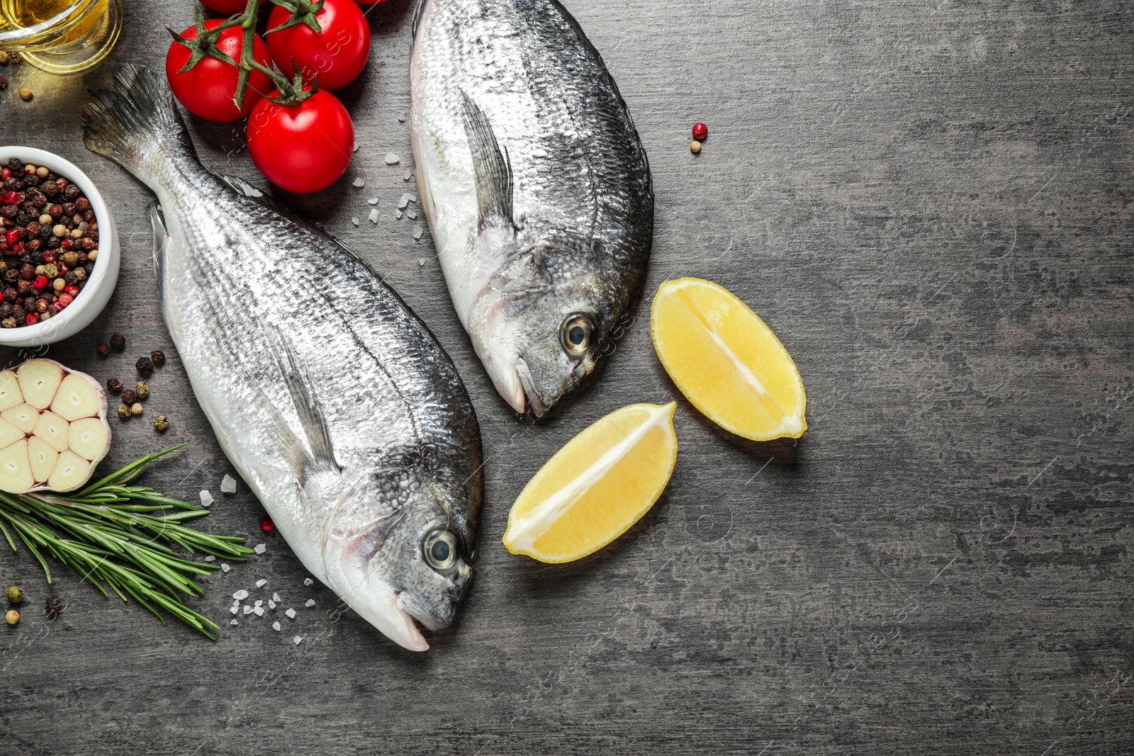 Photo of Flat lay composition with raw dorada fish on grey table