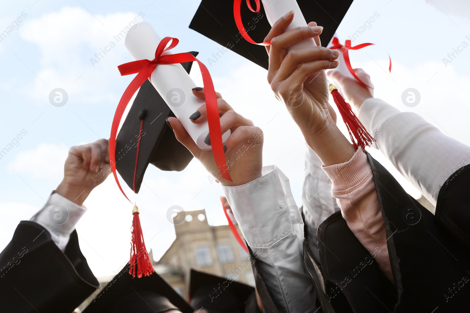 Photo of Group of students with diplomas outdoors, closeup. Graduation ceremony