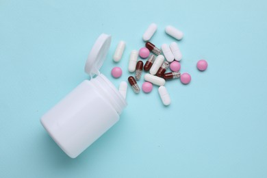 Different antidepressants and medical bottle on light blue background, flat lay