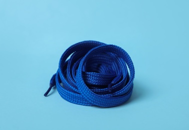Photo of Bright shoe lace on light blue background