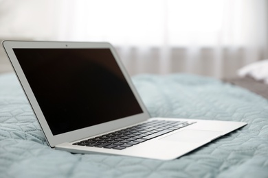 Photo of Modern blogger's laptop with empty screen on bed, space for design