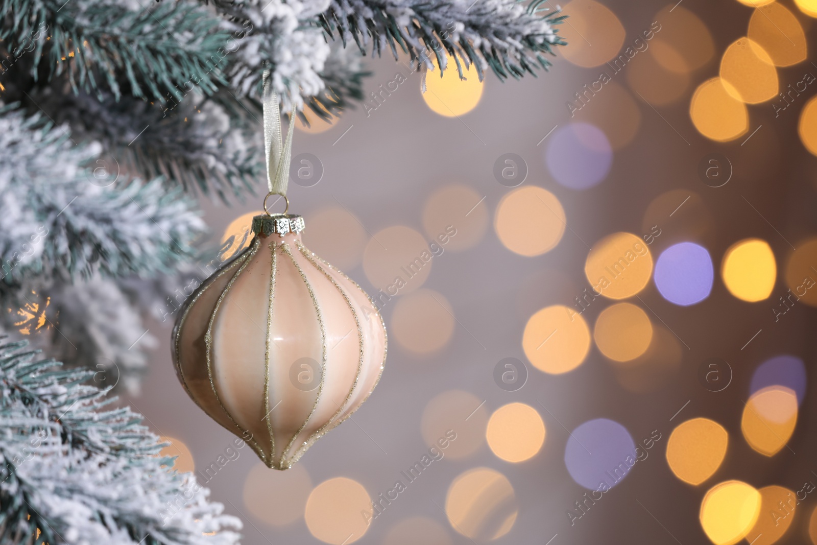 Photo of Christmas tree decorated with holiday bauble against blurred lights, closeup. Space for text