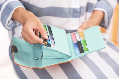 Photo of Woman taking out credit card from stylish wallet, closeup