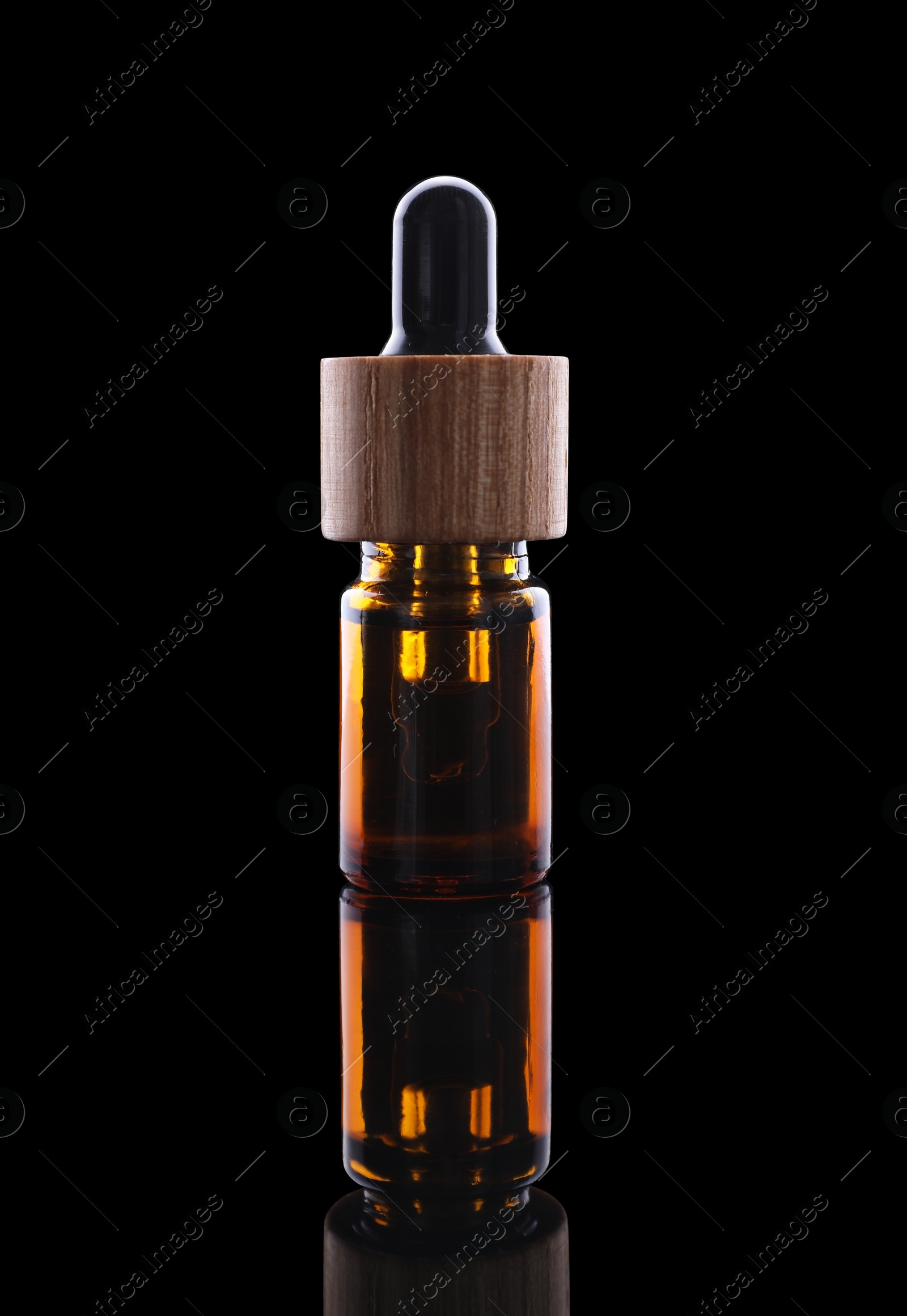 Photo of One brown bottle with tincture on mirror surface against black background