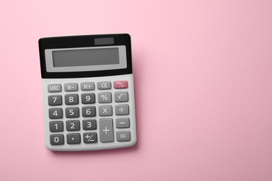 Calculator on pink background, top view. Space for text