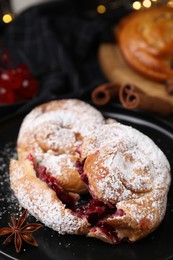 Photo of Delicious buns with berries, sugar powder and anise on plate, closeup