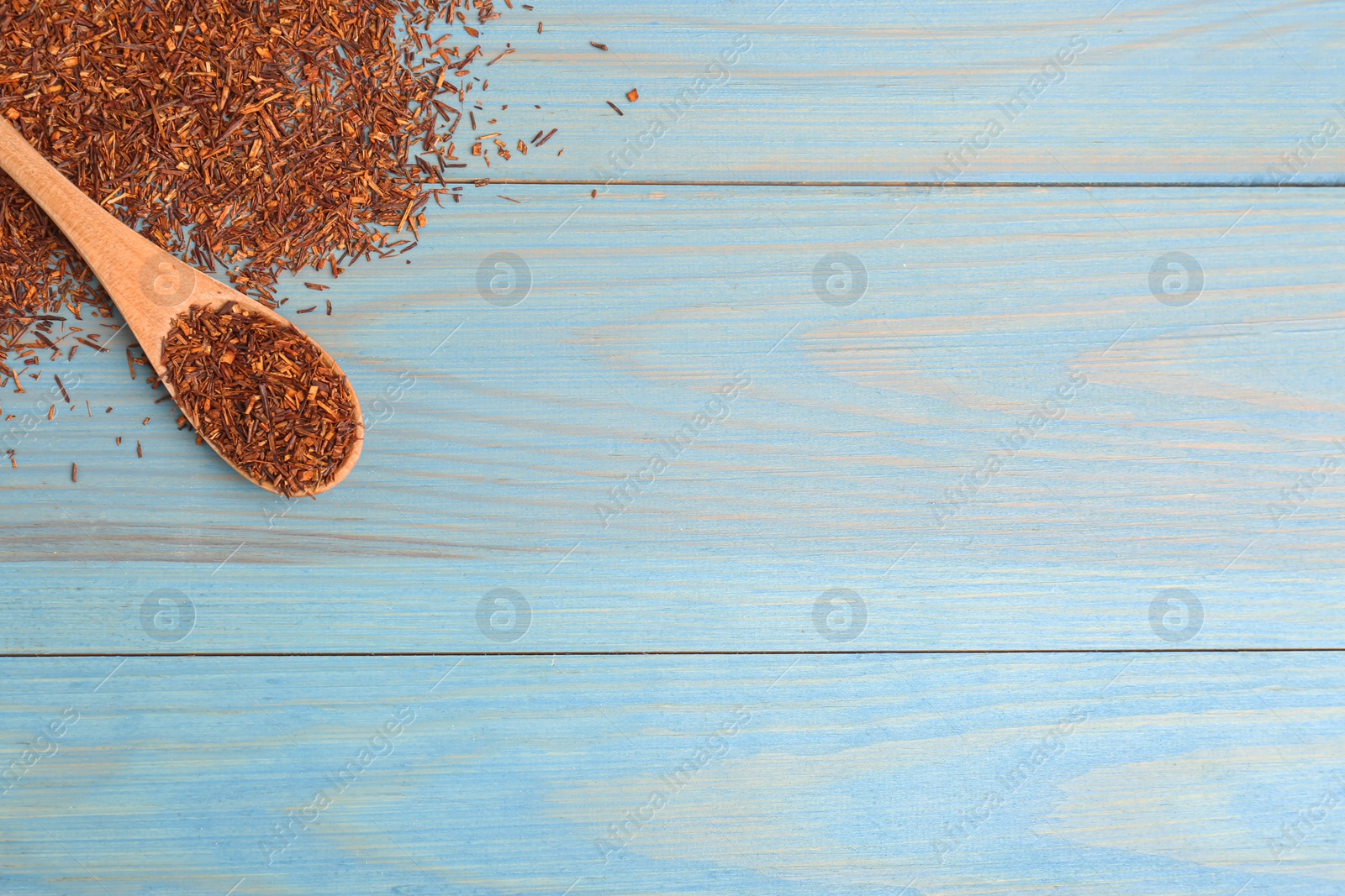 Photo of Dry rooibos leaves and spoon on turquoise wooden table, flat lay. Space for text