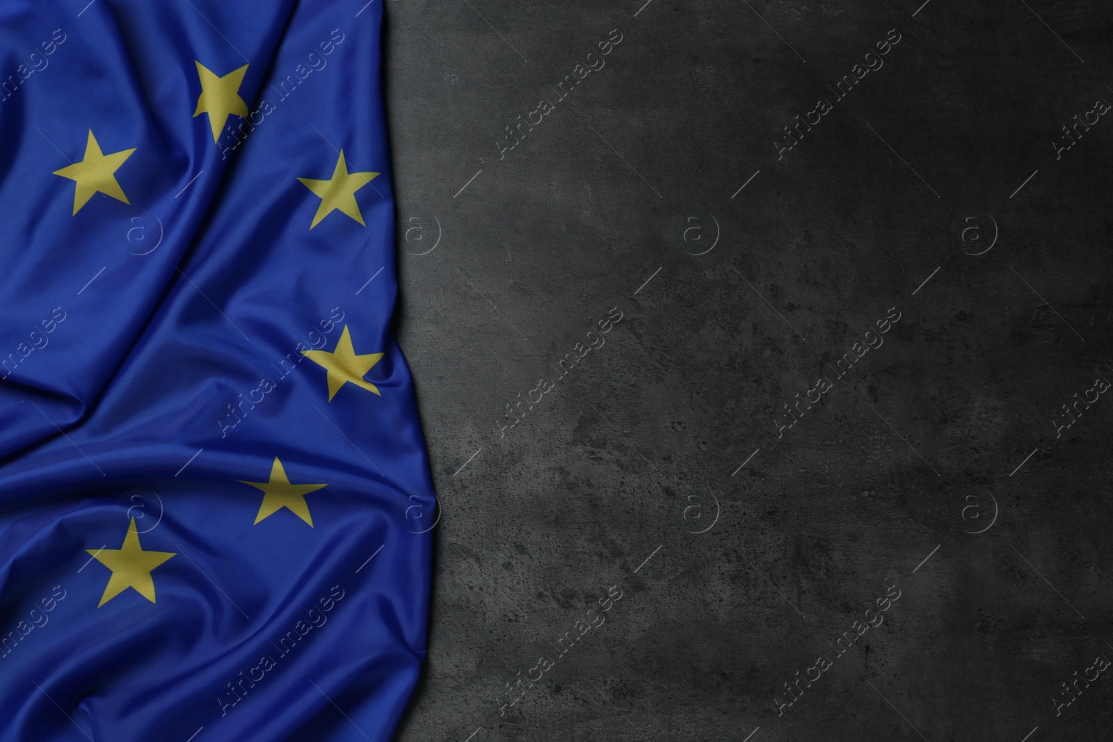 Photo of Flag of European Union on grey stone background, top view. Space for text