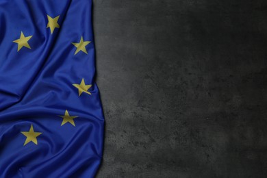 Photo of Flag of European Union on grey stone background, top view. Space for text