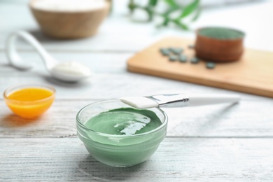 Freshly made spirulina in bowl and brush on white wooden table