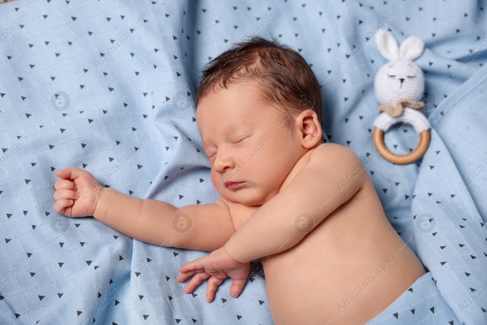 Photo of Cute newborn baby with toy bunny sleeping on bed