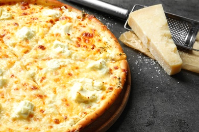 Photo of Tasty hot pizza, cheese and grater on grey background