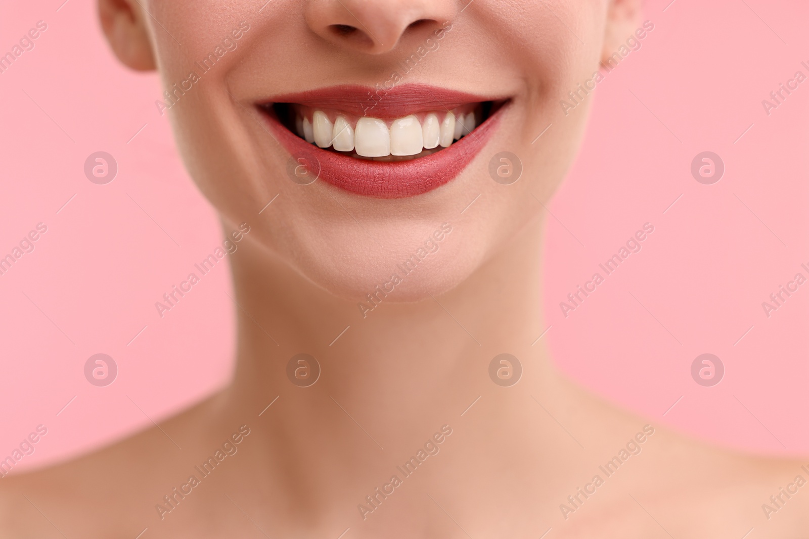 Photo of Woman with beautiful lips smiling on pink background, closeup