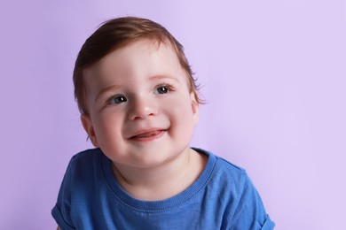 Photo of Cute happy baby boy on violet background