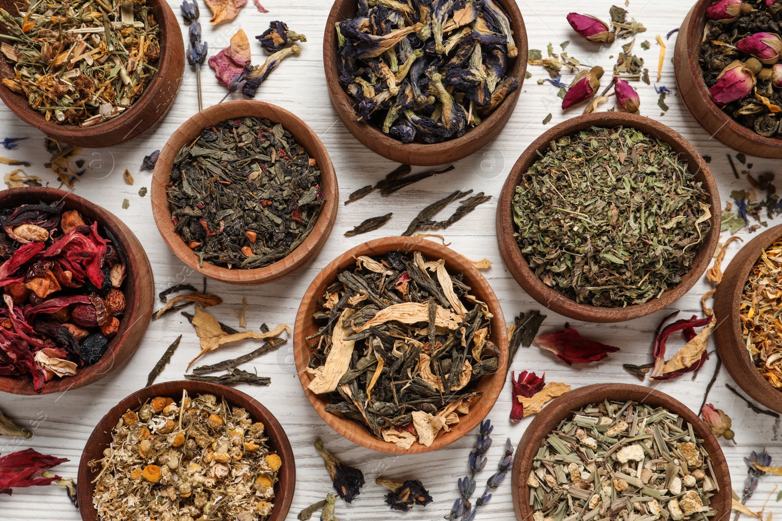 Photo of Flat lay composition with different dry teas on white wooden table