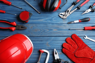 Photo of Flat lay composition with different construction tools and space for text on color wooden background