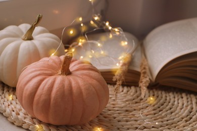 Pumpkins and book on wicker mat indoors