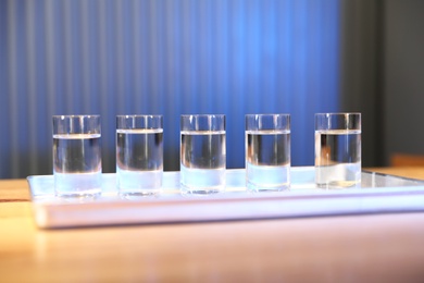 Shots of vodka on wooden bar counter
