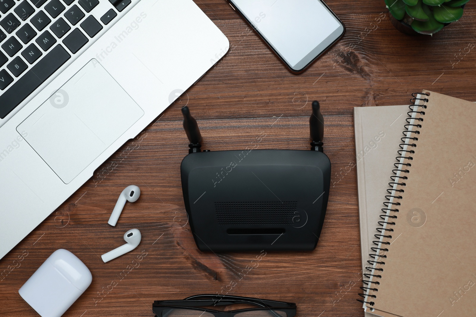 Photo of Composition with router, laptop and office stationery on wooden table, flat lay