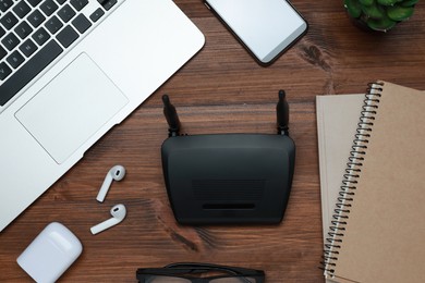 Photo of Composition with router, laptop and office stationery on wooden table, flat lay