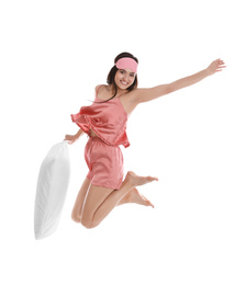 Photo of Beautiful woman with pillow jumping on white background. Bedtime