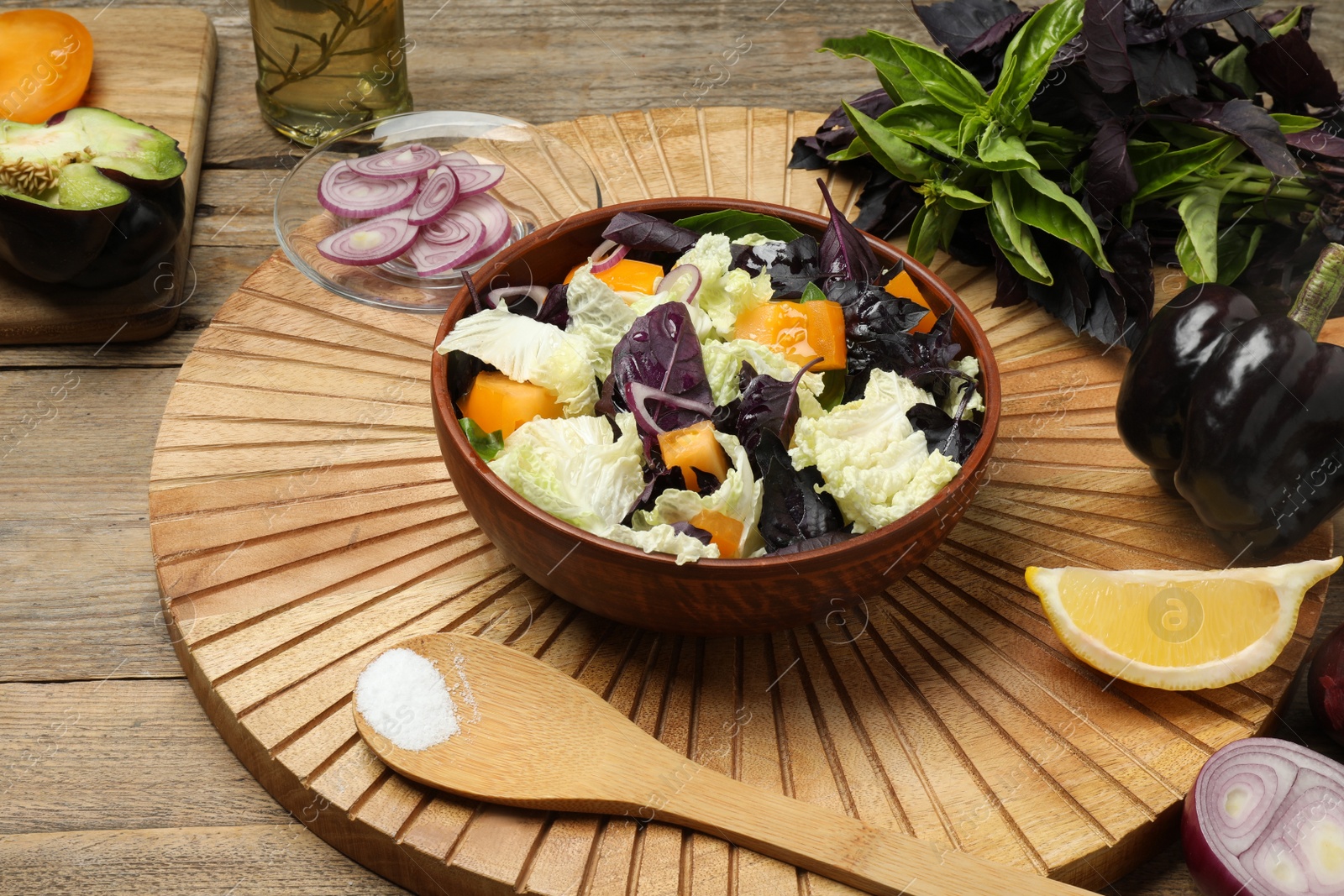 Photo of Delicious salad with Chinese cabbage, tomato and basil served on wooden table