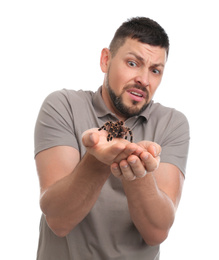 Photo of Scared man holding tarantula on white background. Arachnophobia (fear of spiders)