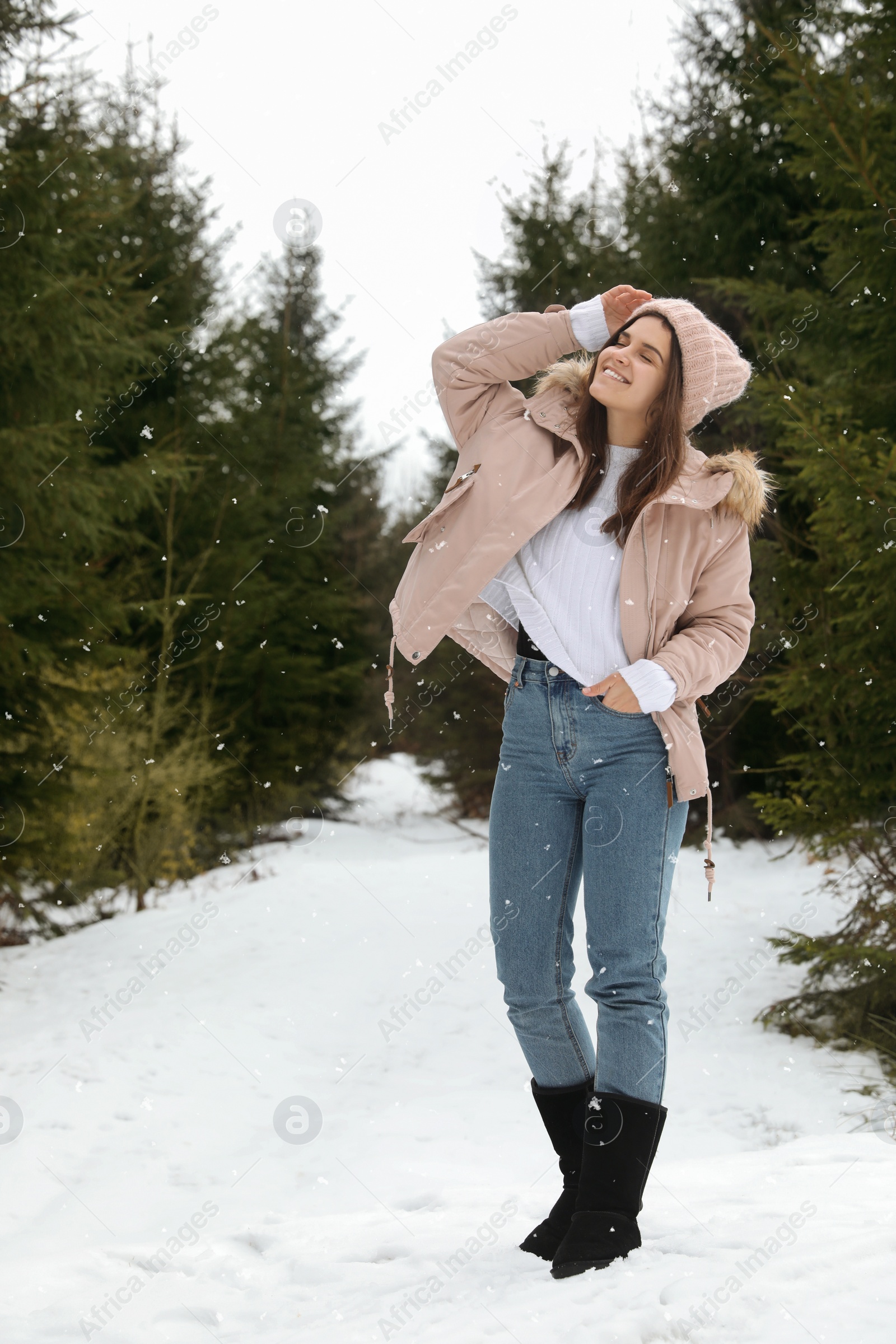 Photo of Young woman in snowy conifer forest. Winter vacation