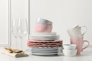 Photo of Beautiful ceramic dishware, glasses, cups and cutlery on white marble table