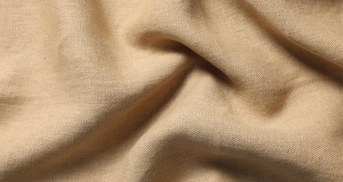 Texture of beige crumpled fabric as background, closeup