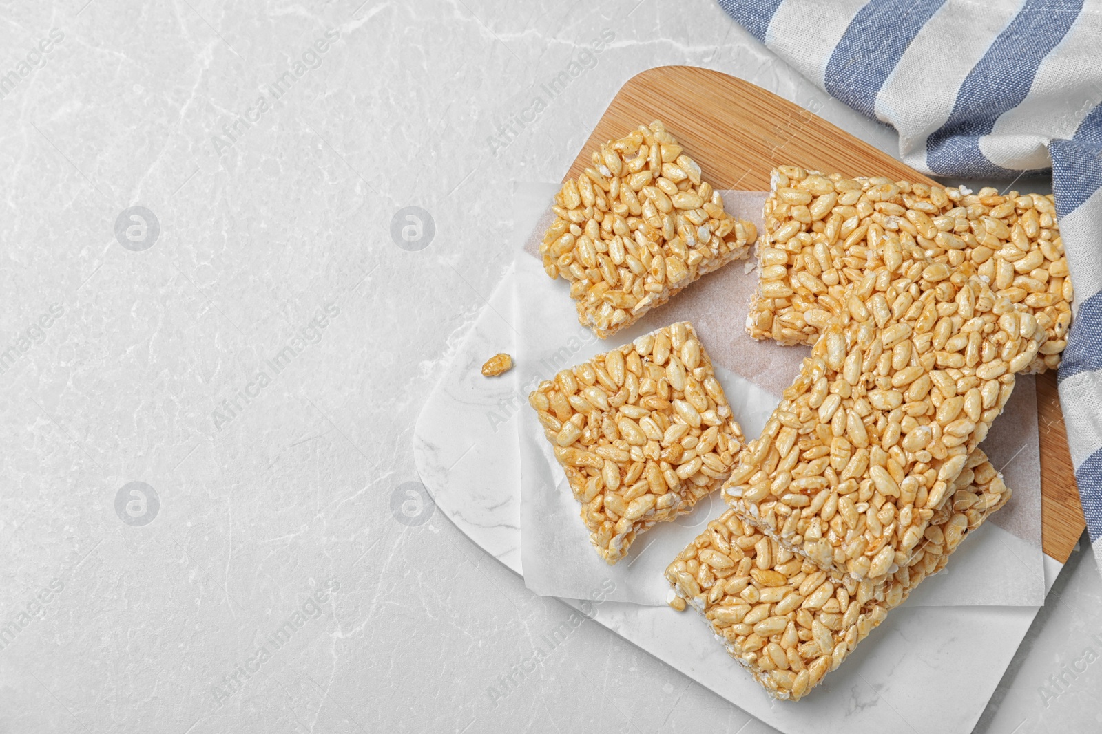 Photo of Delicious rice crispy treats on light grey table, flat lay. Space for text