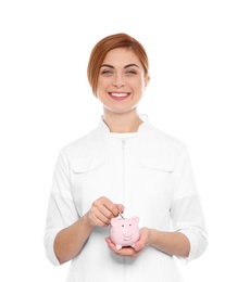 Photo of Portrait of female doctor with piggy bank on white background