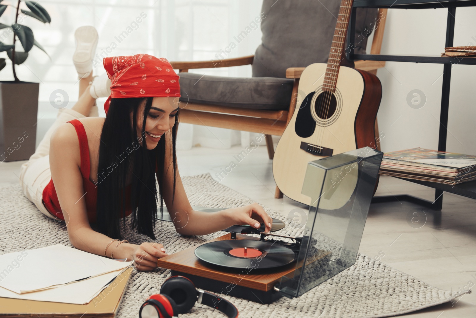 Photo of Woman listening to music with turntable at home