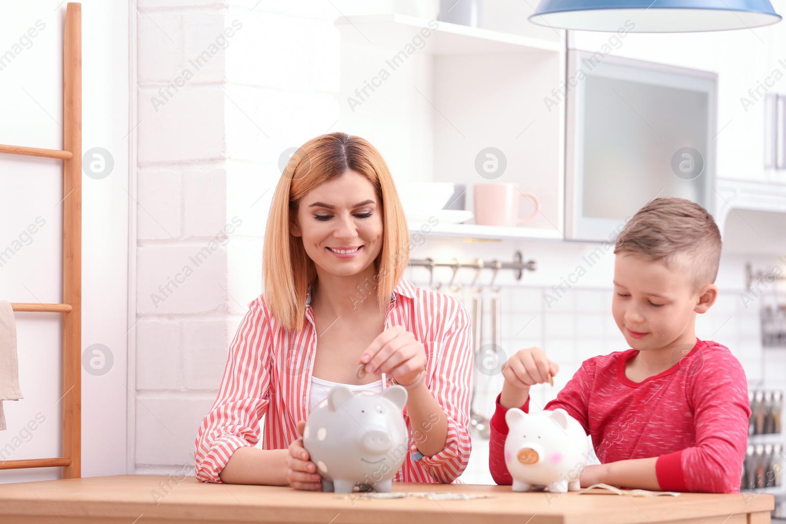 Photo of Family with piggy banks and money at home