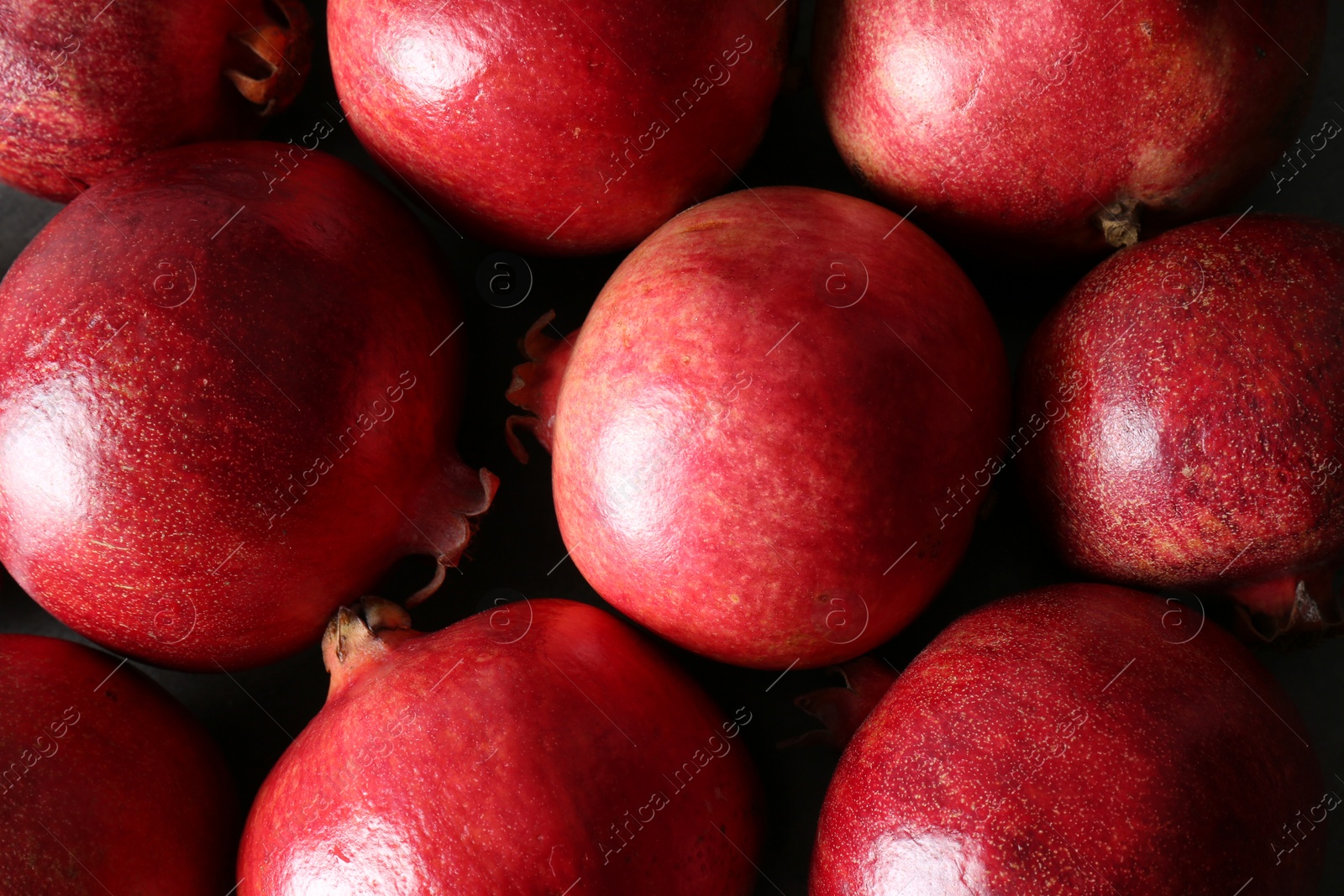 Photo of Delicious red ripe pomegranates on table, top view