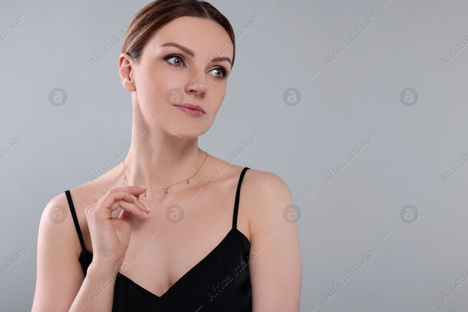 Photo of Beautiful woman with elegant necklace on light grey background. Space for text