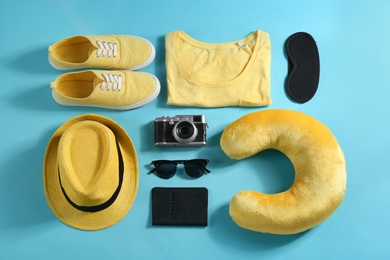 Photo of Flat lay composition with travel pillow and tourist stuff on light blue background