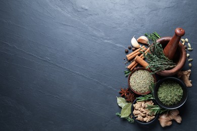 Photo of Flat lay composition with different natural spices and herbs on black table, space for text