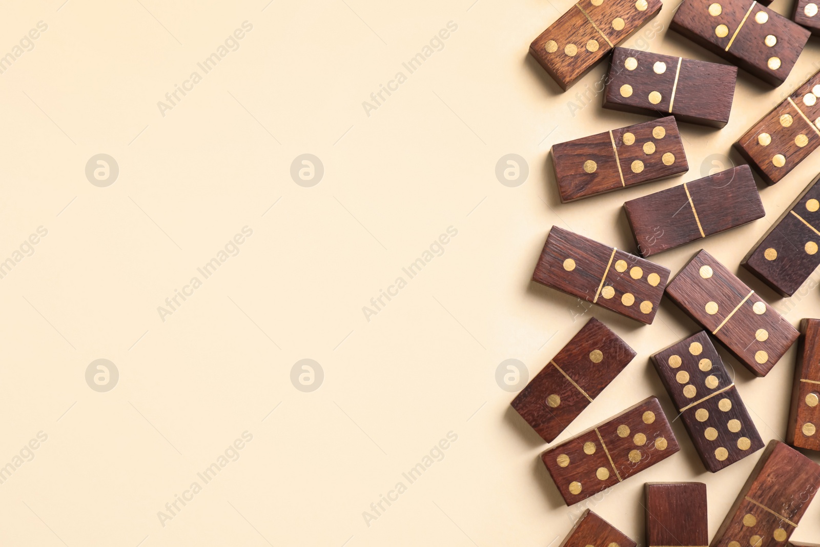 Photo of Wooden domino tiles on beige background, flat lay. Space for text