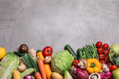 Photo of Different fresh vegetables on grey background, flat lay. Space for text