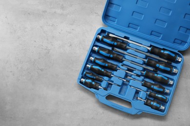 Photo of Set of screwdrivers in open toolbox on light table, top view. Space for text