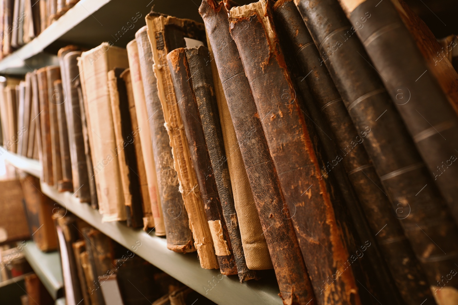 Image of Different old books on shelf in library, closeup