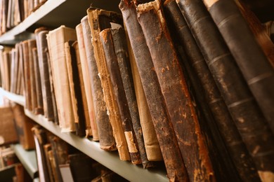 Image of Different old books on shelf in library, closeup