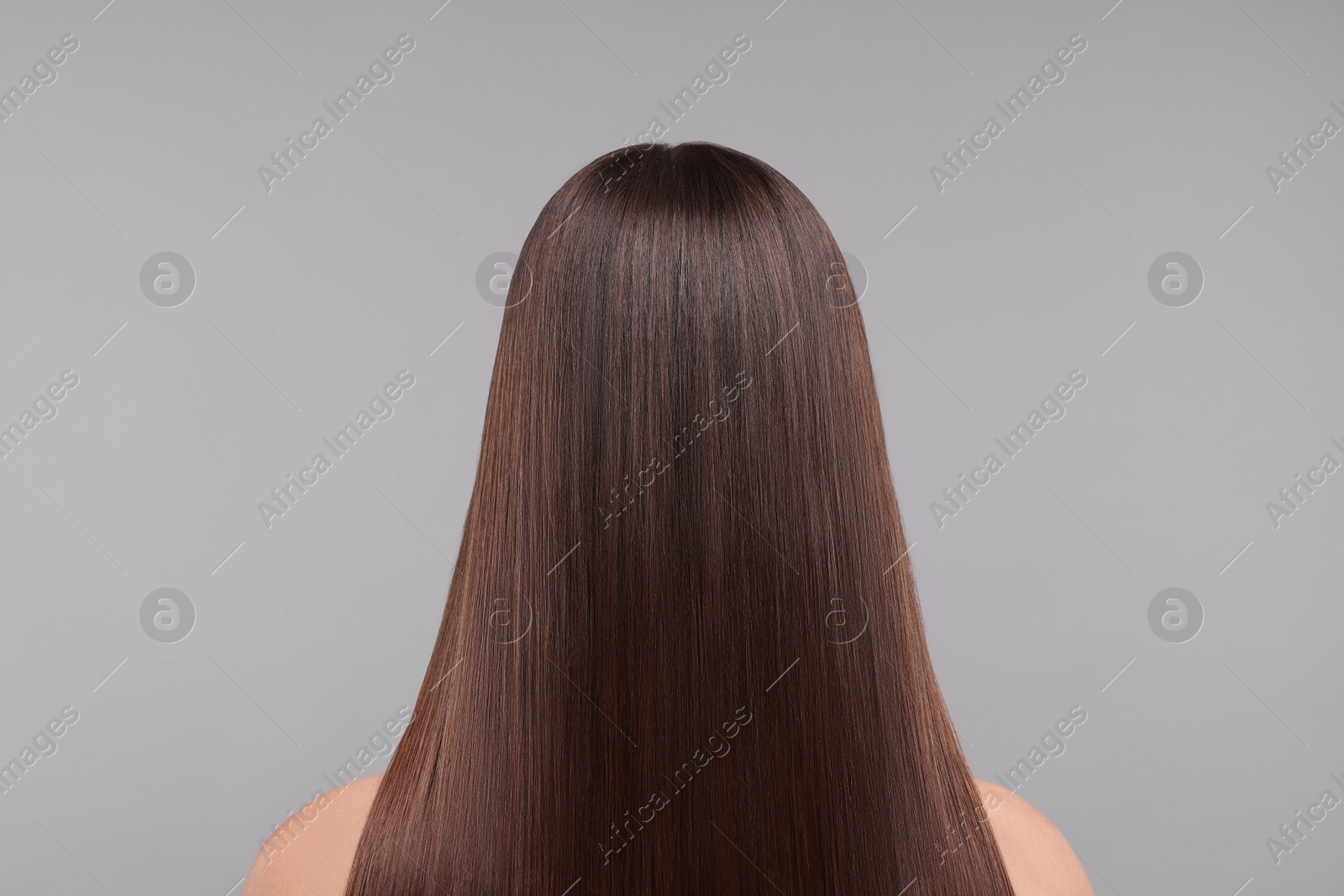 Photo of Woman with smooth healthy hair after treatment on light grey background, back view