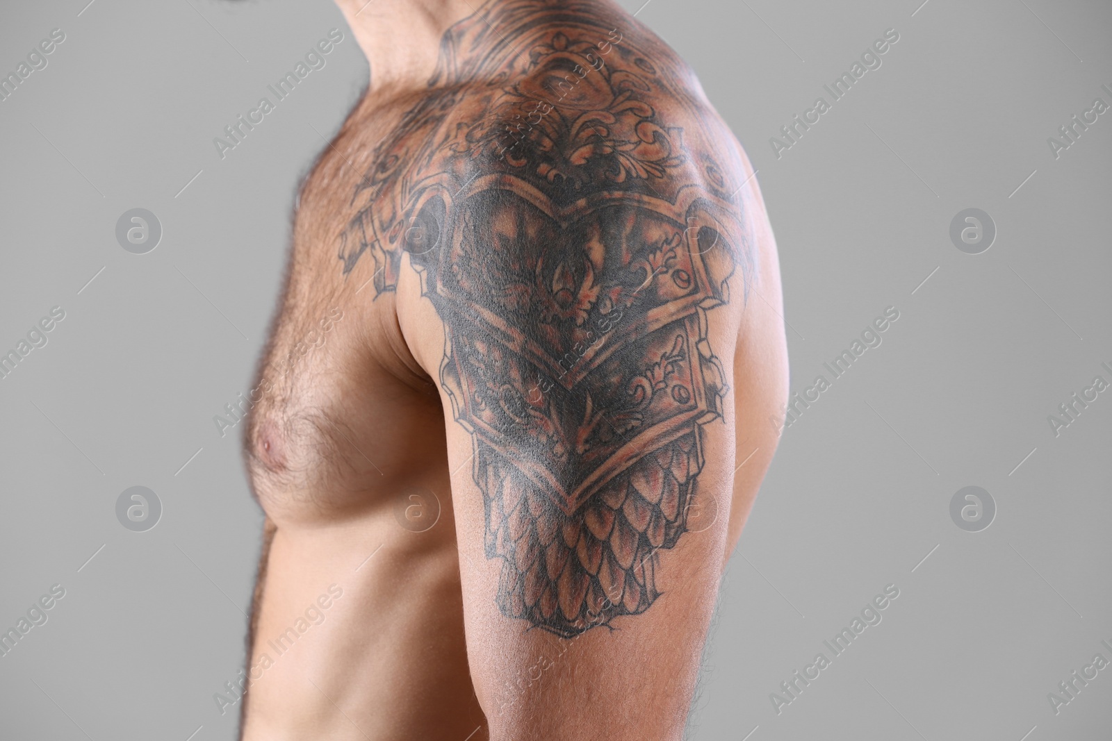 Photo of Tattooed man on grey background, closeup view