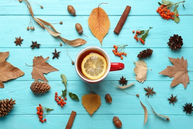 Photo of Flat lay composition with cup of hot drink on blue wooden table. Cozy autumn atmosphere