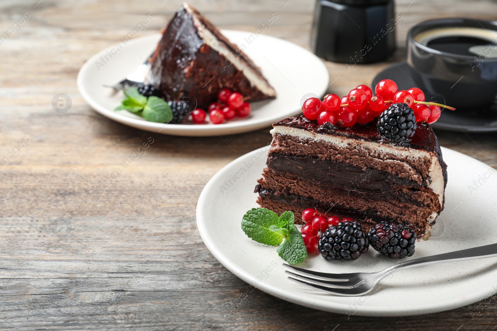 Photo of Tasty chocolate cake with berries on wooden table. Space for text